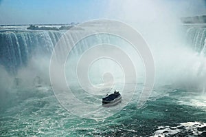 Niagara Horseshoe Falls with a touristic vessel Maid of the Mist approaching. The falls height is 57 m and they throw