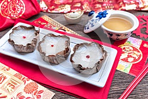 Nian Gao or sticky rice cake and red envelope Cash Gift on wooden background