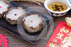 Nian Gao or sticky rice cake and Tea with Red Envelope Cash gift on wooden background  Chinese New Year`s concept