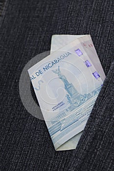 nicaraguan banknote of 100 cordobas between blue denim fabric