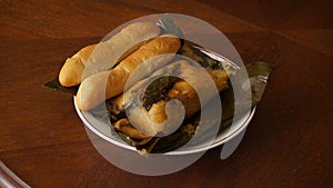 Nicaraguan dish of nacatamal accompanied by bread on a table.