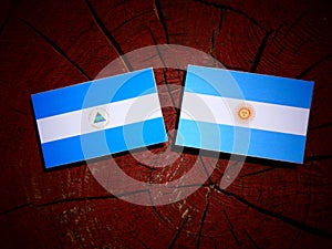 Nicaraguan flag with Argentinian flag on a tree stump isolated