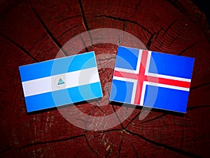 Nicaraguan flag with Icelandic flag on a tree stump isolated