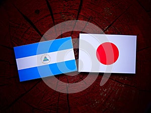 Nicaraguan flag with Japanese flag on a tree stump isolated