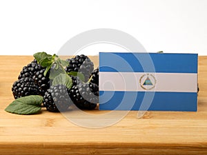 Nicaraguan flag on a wooden panel with blackberries isolated on