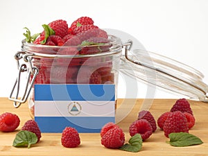 Nicaraguan flag on a wooden panel with raspberries isolated on a