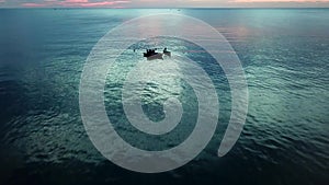 Nice aerial video on two vietnamese traditional boats with two fisherman work at sea, quiet evening after sunset, close to Phu