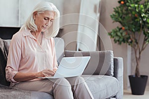 Nice aged woman using her laptop at home