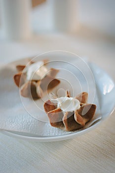 Nice appetizer snacks - tartlets on a white ceramic plate.