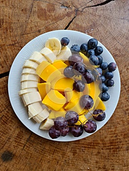nice arranged fruits on a plate, , blueberries, mango, ananas, grapes, bananas