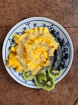 nice arranged fruits on a plate, , blueberries, mango, kiwis