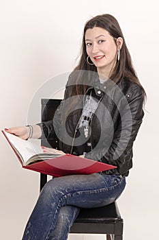 Nice asian girl in black jacket with a red book.