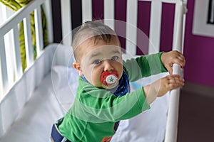 Nice baby in cradle with green bodysuit