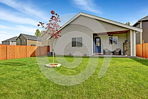 Nice back yard with well kept lawn and view of covered porch with fireplace