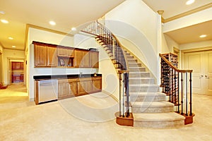 Nice basement staircase with metal railing and beige carpet.