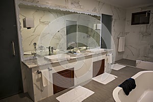 Nice bathroom with two sinks, a large mirror, a shower and a white bathtub