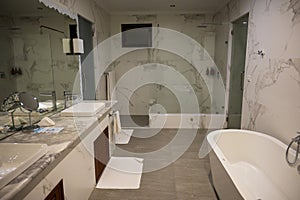 Nice bathroom with two sinks, a large mirror, a shower and a white bathtub