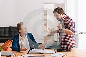 Nice bearded man explaining something to his colleague