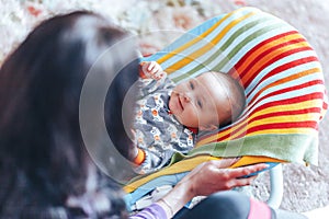 nice blue eyed Baby child relaxing on a sunbed or a deck chair colored bouncer at home