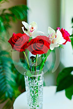 Nice bouquet from red roses and white orchids in vase  on white background