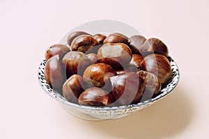 A nice bowl of chestnuts on beige background