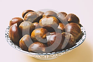 A nice bowl of chestnuts on beige background