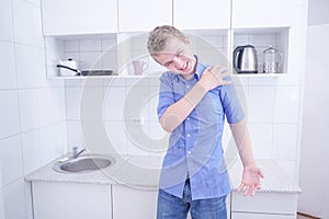 Nice boy in blue shirt with emotions on kitchen alone