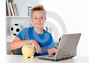 Nice boy with laptop and piggy bank photo