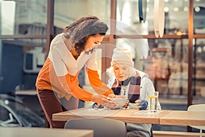 Nice cheerful woman holding a bowl with soup