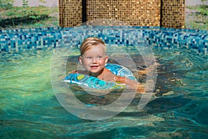 Nice child swiming in blue small pool