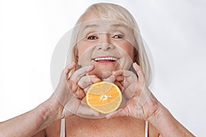 Nice content woman holding an orange