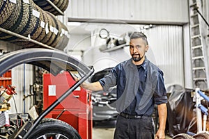 Nice and cool mechanic changing car tire at work