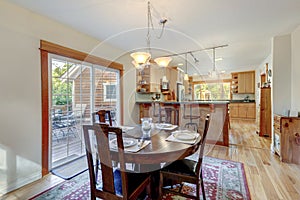 Nice country home wood kitchen with wooden island and ligth green tiles with dining room  dark cherry round table