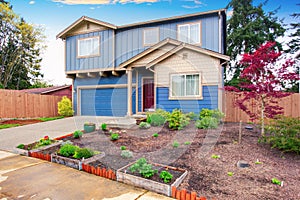 Nice curb appeal of blue house with front garden.