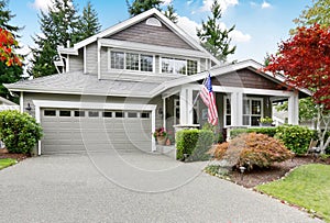 Nice curb appeal of grey house with covered porch and garage