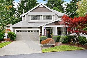 Nice curb appeal of grey house with covered porch and garage