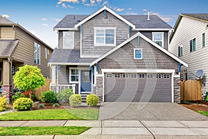 Nice curb appeal of two level house, mocha exterior paint and concrete driveway photo