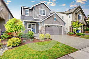 Nice curb appeal of two level house, mocha exterior paint and concrete driveway photo