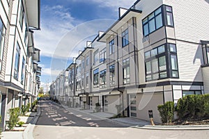 Nice development of new townhouses. External facade of a row of colorful modern urban townhouses.brand new houses just after const