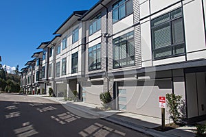 Nice development of new townhouses. Rows of townhomes side by side. External facade of a row of colorful modern urban townhouses.