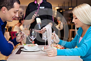 Nice dinner in a restaurant - waiter offers wine