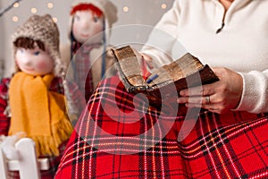 A nice elderly woman sews to knit her granddaughters in a Christmas arrangement