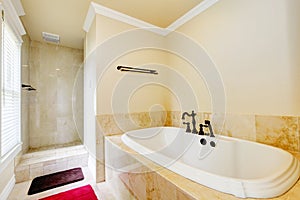 Nice empty bathroom with large white tub and shower.