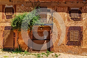 Nice facade of stone houses with colorful plants and flowers at the entrance. Spain photo