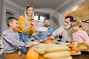 Nice family having tasty dinner. Food, thanksgiving day and leisure concept - family eating pasta and delicious meal for