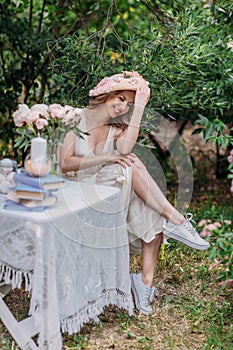 Nice fashion girl in straw hat with flowers and a retro dress