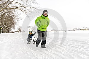 A nice Father drag his boy in sled