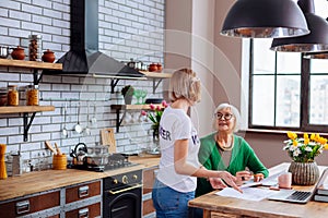 Nice female explaining elderly dame items of overdue loan notification