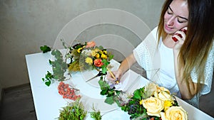 Nice female flower designer accepts order for flower arrangement