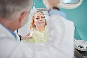 Nice female patient smiling in dental chair